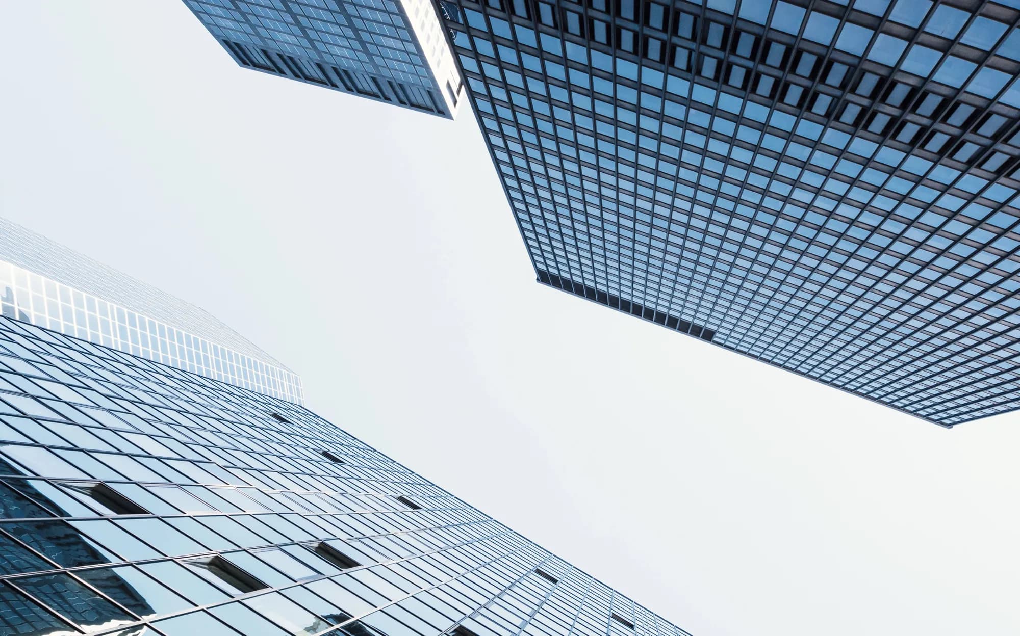 Upward view between modern glass office buildings