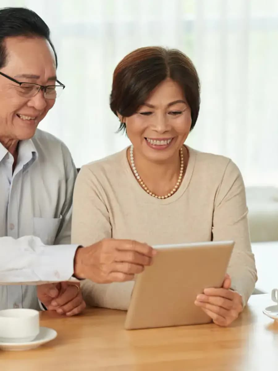 Mature Asian couple reviewing information together on a tablet